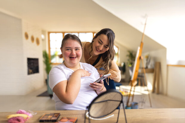 2 Frauen schminken sich und sind glücklich