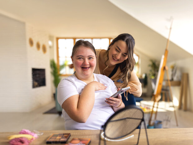 2 Frauen schminken sich und sind glücklich