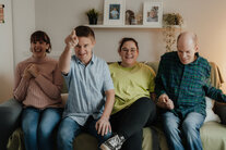 Eine Gruppe von Menschen sitzen auf der Couch und lachen