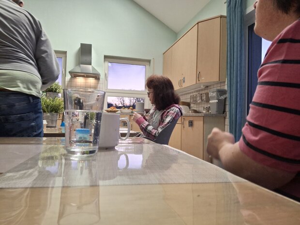 Die Bewohner der Wohngruppe von Noh Bieneen sitzen gemeinschaftlich in der Küche